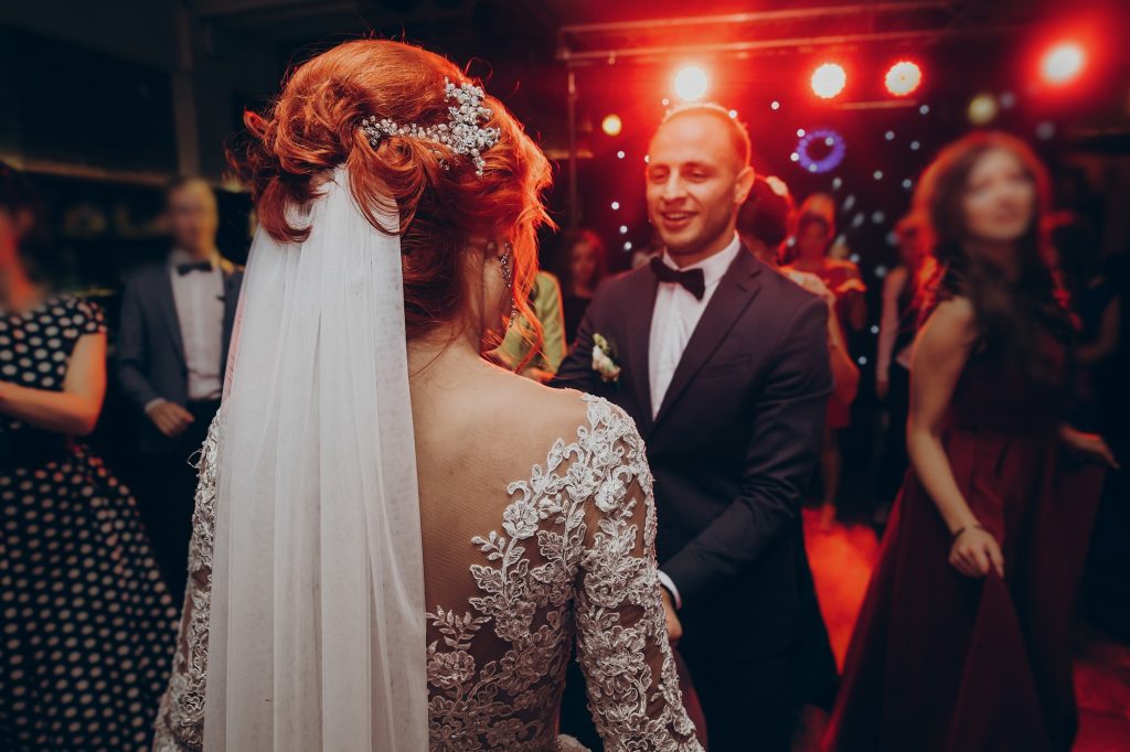 Gorgeous wedding couple having fun and partying in restaurant in light show