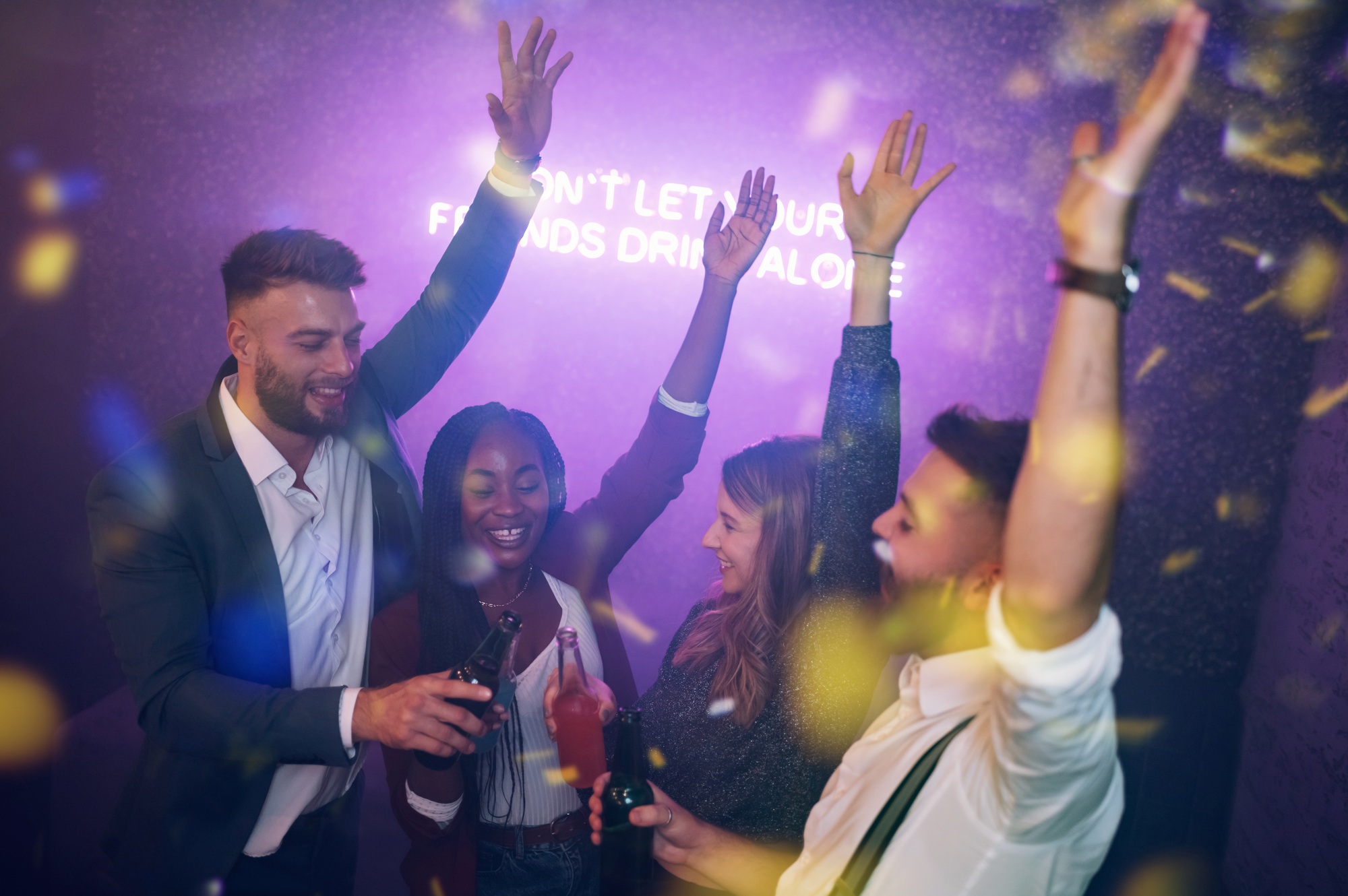 Happy group of friends dancing on a party in a club