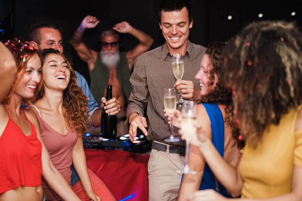 Young multiracial friends dancing at home private party - Focus on center man face